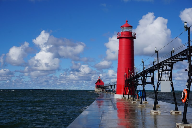 Red and white lighthouse at the end of a Lake Michigan pier